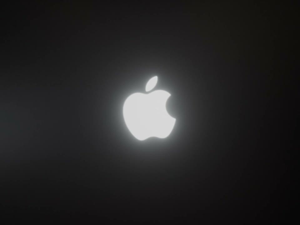 The Apple logo on the closed lid, lit up in the dark